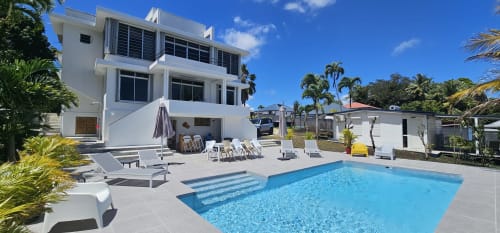 Moderne weiße Villa im Habitation Villa Les Cassias mit glitzerndem Pool, Liegestühlen und tropischem Garten in Petit
