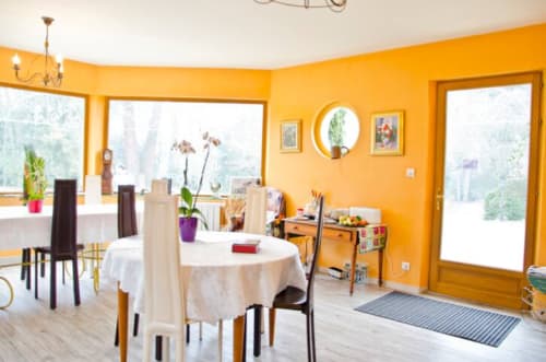 Bright yellow dining room with garden views at Manoir De La Maison Blanche in Amboise, featuring round table and modern