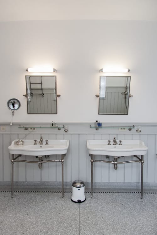 Dual pedestal sinks with mirrors and sconces in Castanea Business & Suites bathroom, Merelbeke