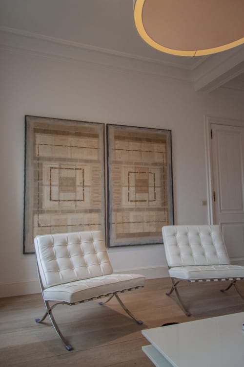 Modern lounge at Castanea Business & Suites Merelbeke with white Barcelona chairs and geometric wall art