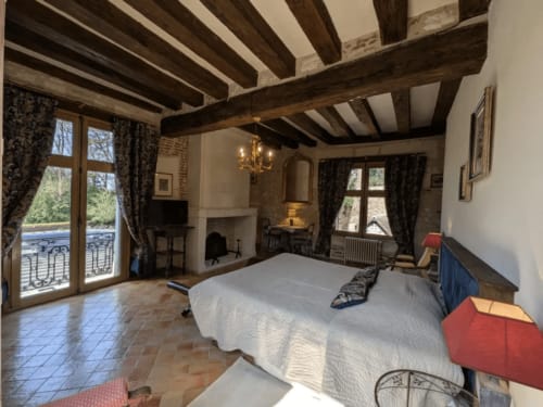 Suite luxueuse au Manoir De La Maison Blanche à Amboise avec poutres apparentes, cheminée et vue sur le jardin