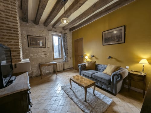 Suite lusso al Manoir De La Maison Blanche ad Amboise con pareti color senape, travi a vista e mobili d'epoca