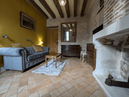 Soggiorno della Suite Deluxe al Manoir De La Maison Blanche, Amboise, con divano blu, travi a vista e camino
