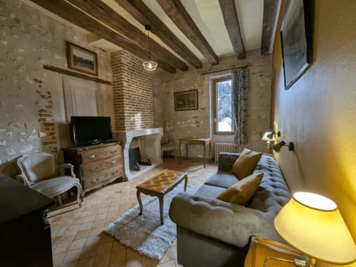 Suite Deluxe al Manoir De La Maison Blanche ad Amboise con salotto, camino, divano, TV e travi a vista