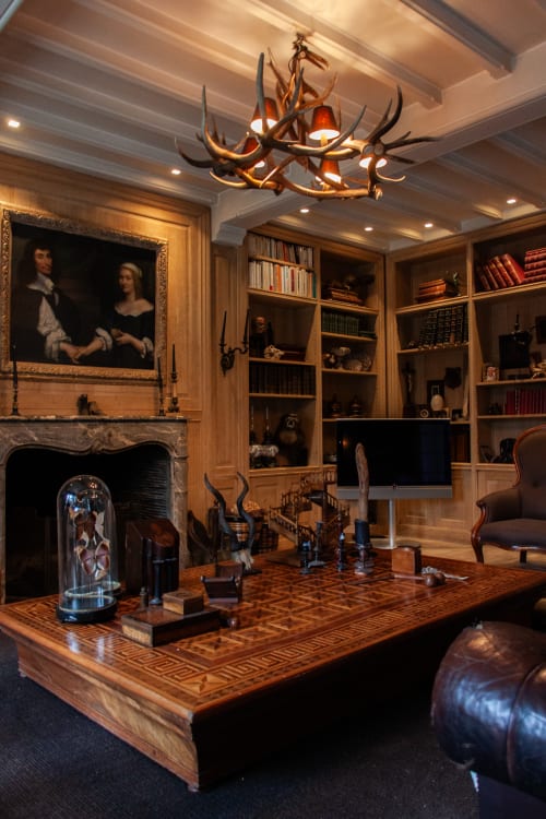 Luxury study with antler chandelier, fireplace, wooden desk, bookshelves and portrait at Castanea Business & Suites,