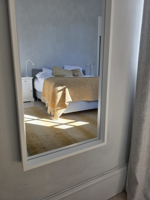Bedroom view through glass door at Castanea Business & Suites in Merelbeke, Belgium showing bed with gold throw and white