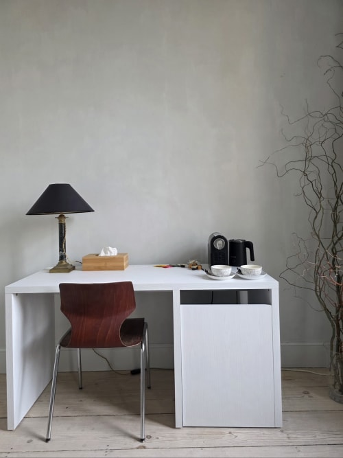Modern white desk with red chair, lamp, and coffee maker at Castanea Business & Suites in Merelbeke