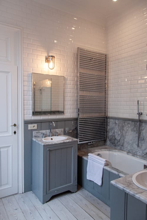 Modern bathroom at Castanea Business & Suites in Merelbeke with white subway tiles, grey vanity, heated towel rack and