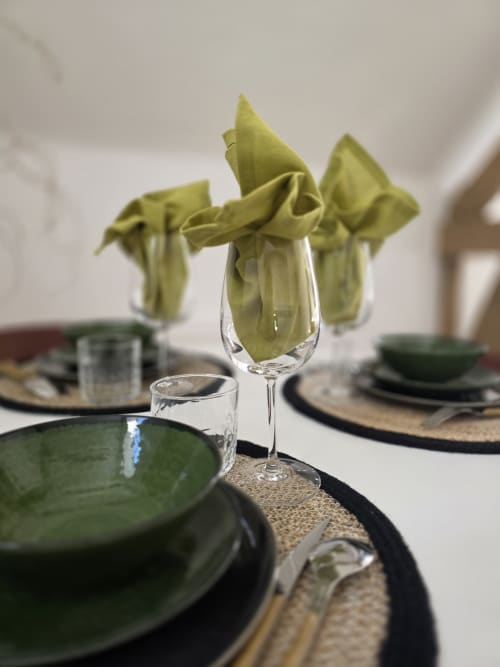 Elegant table setting at Castanea Business & Suites with olive green napkins, place settings, and glassware