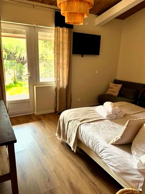 Bright bedroom at Hôtel du Pont Blanc with garden view, flat-screen TV, modern furnishings and garden access