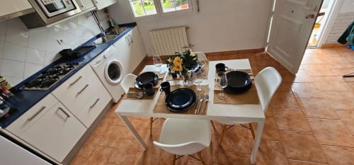 Cocina-comedor del apartamento Bizkar Bare con mesa puesta, vajilla negra y vistas al jardín en Vizcaya