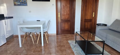 Moderna sala de estar de apartamento en el hotel Bizkar Bare en Vizcaya con mesa de comedor, sofá y puertas de madera