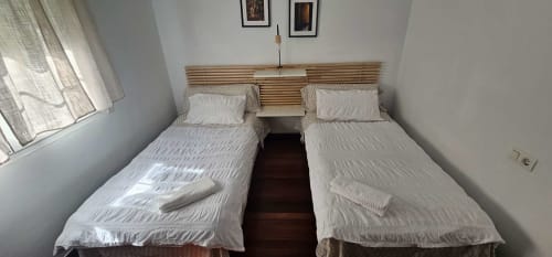 Camas gemelas con ropa de cama blanca en el apartamento Bizkar Bare, Vizcaya, España con vistas al jardín