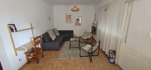 Sala de estar del apartamento Bizkar Bare con sofá oscuro, muebles de madera y vistas al jardín en Vizcaya