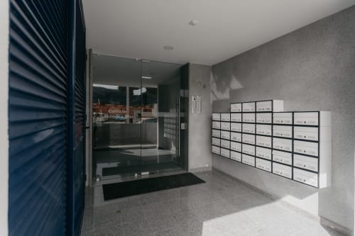 Entrada de edificio moderno con buzones y puertas de cristal en Sesimbra, Portugal