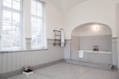 Luxurious bathroom in Bernard Suite at Castanea Business & Suites with soaking tub, heated towel rack, and garden views.