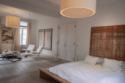 Bernard Suite at Castanea Business & Suites in Merelbeke featuring a bed, sitting area with chairs, and modern lighting
