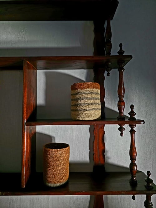 Wooden shelving with woven baskets and decorative wooden finials in Castanea Business & Suites Thérèse Suite