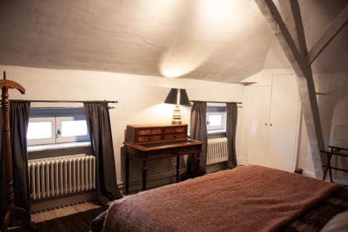 Thérèse Suite bedroom with wooden furniture, sloped ceiling, and garden views at Castanea Business & Suites in Merelbeke