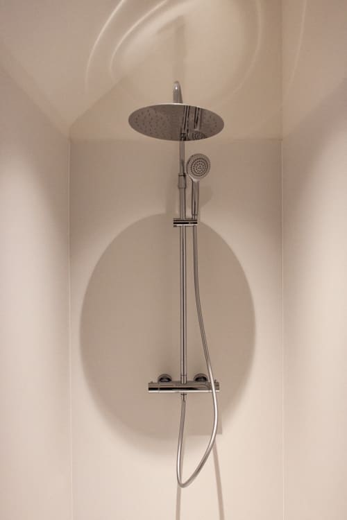 Modern chrome shower system with rainfall showerhead in Studio Fabienne at Castanea Business & Suites, Merelbeke