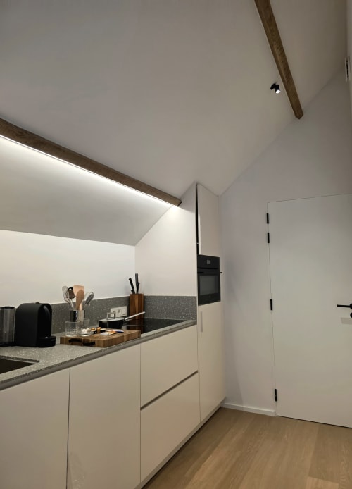 Modern kitchen in Studio Fabienne at Castanea Business & Suites, Merelbeke, with white cabinets and gray countertop