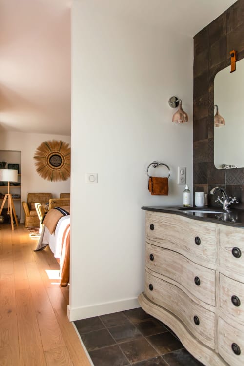 Elegant bathroom at Villa Figue Blanche with wooden vanity, black countertop, and copper fixtures in Montagny-les-Buxy