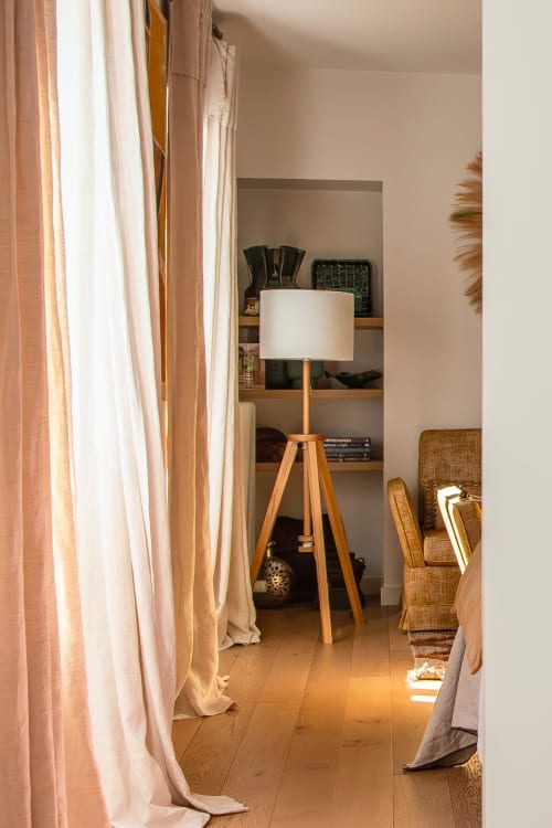 Modern bedroom at Villa Figue Blanche with wooden tripod lamp, built-in shelving, and flowing curtains in Montagny-les-Buxy