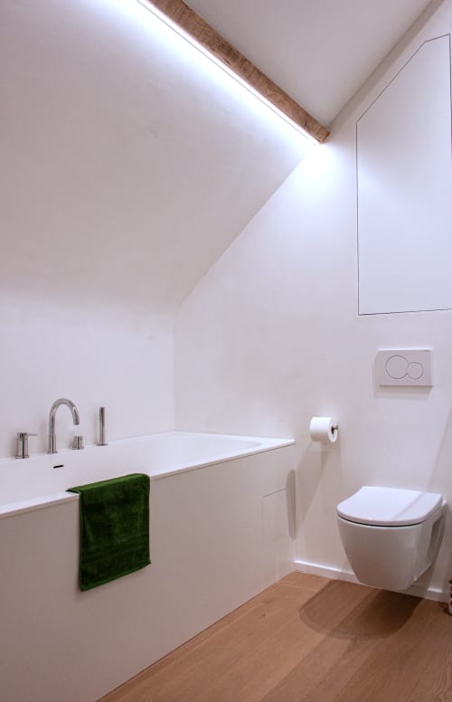 Modern bathroom in Studio Catherine apartment at Castanea Business & Suites featuring white fixtures, wooden accents, and