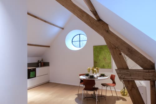 Bright studio apartment at Castanea Business & Suites in Merelbeke with modern dining area, exposed beams, and circular