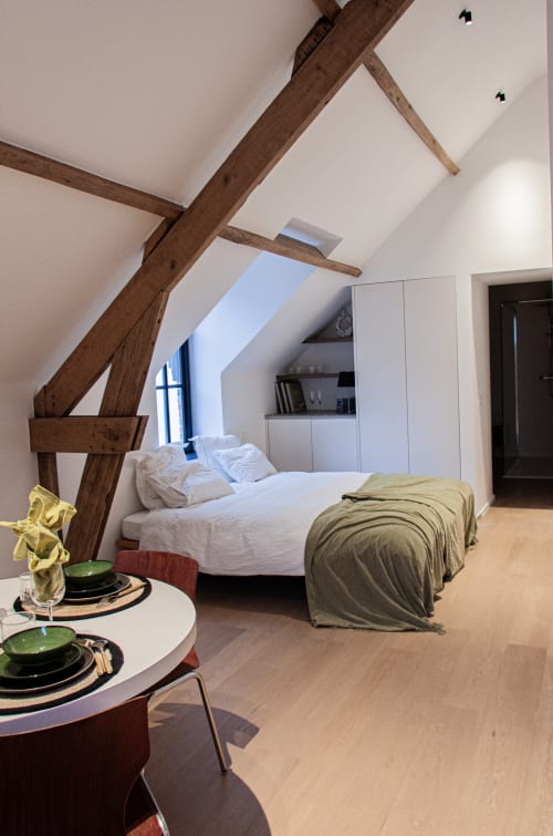 Studio Catherine at Castanea Business & Suites in Merelbeke - modern loft bedroom with exposed wooden beams, white bedding,