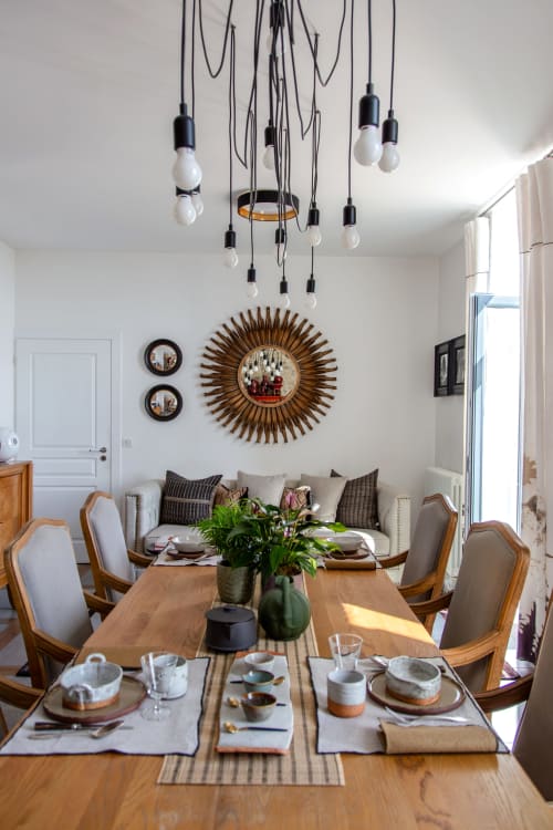 Dining room at Villa Figue Blanche with wooden table, pendant lights, and sunburst mirror, Montagny-les-buxy