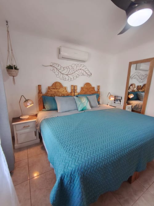 Dormitorio costero en Casa Punta Perula con ropa de cama turquesa, cabecero de madera y decoración inspirada en el océano en Jal, MX