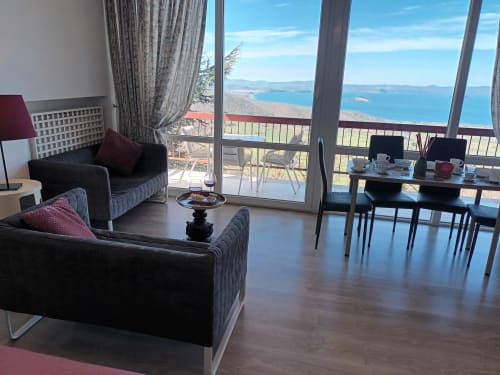 Elegant suite at Belvedere del Lago in Montefiascone with panoramic lake views from balcony, modern seating, and dining area