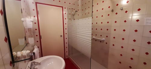 Modern bathroom in Rosa Suite at Belvedere del Lago, Montefiascone, with red diamond tile pattern and walk-in shower