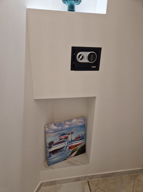 Nicchia murale a Sikelia House Cefalù con opera raffigurante barche, lucernario soprastante e tastiera digitale della cassaforte