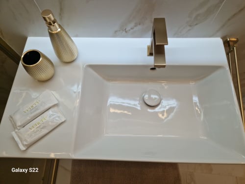 Lussuoso lavabo della Sikelia House Cefalu con rubinetto dorato, articoli da bagno e piano in marmo