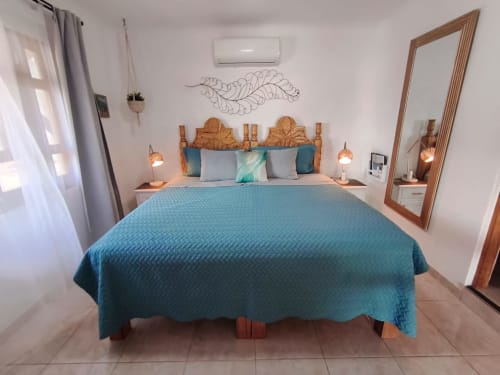 Habitación frente al mar con ropa de cama turquesa, cabecero de madera y vistas al mar en Casa Punta Perula, Punta Perula México