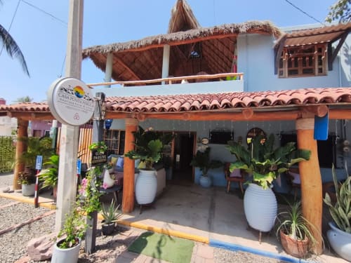 Entrada del Boutique Hotel Casa Punta Perula en Punta Perula con azulejos de barro, macetas blancas y decoración tropical