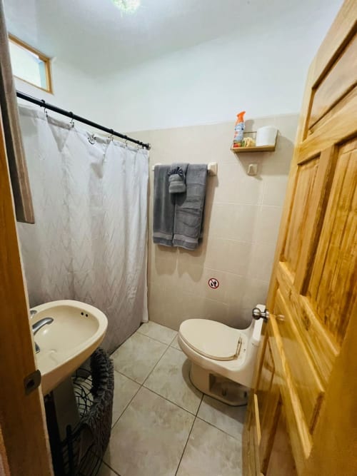 Baño moderno con ducha, inodoro y piso de cerámica en Casa Punta Perula, boutique hotel en Punta Perula, México