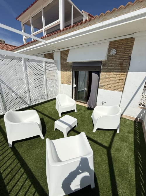 Moderna terraza en azotea del Apartamento 7 en Matalascañas con mobiliario contemporáneo blanco y césped artificial con vistas