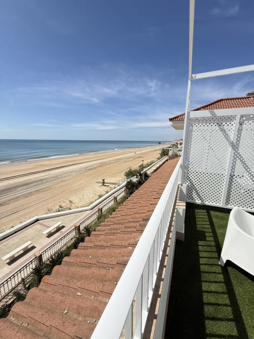 Terraza de apartamento frente al mar en Matalascañas con vistas al océano, playa de arena y cielo azul