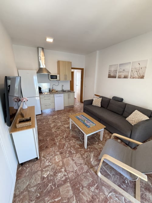 Moderno apartamento estudio en Matalascañas con cocina abierta, sala de estar, sofá, TV y vistas al mar