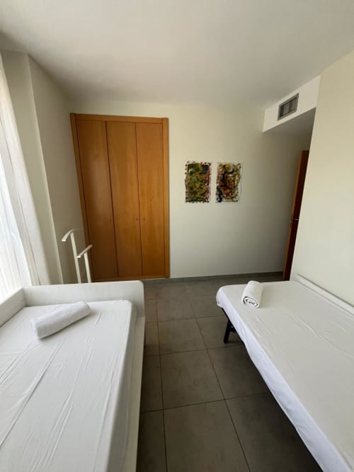 Chambre twin spacieuse de l'appartement Sant Jordi avec carrelage, armoires en bois et vues sur la montagne