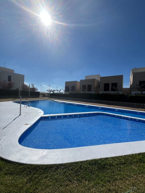 Piscine commune et appartements modernes à Home Guardian Services à Sant Jordi avec vue sur les montagnes sous un ciel ensoleillé