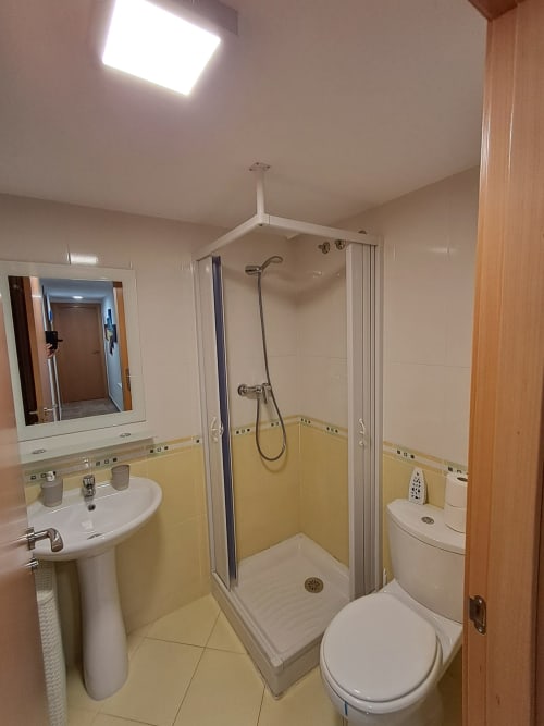 Salle de bain moderne avec douche, toilettes et lavabo à l'appartement Residencia Golfmar, Sant Jordi