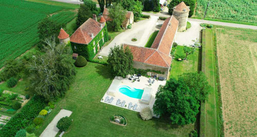 Vue aérienne du Château de Ribourdin avec tours, jardins paysagés, piscine et champs environnants à Chevannes
