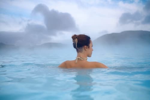 Femme se relaxant dans les eaux thermales des Hortensias à Bourbonne-les-Bains, avec vue sur les montagnes