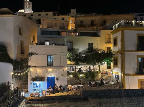 Hotel La Ventana's nighttime terrace with dining guests overlooking Ibiza's Old Town architecture