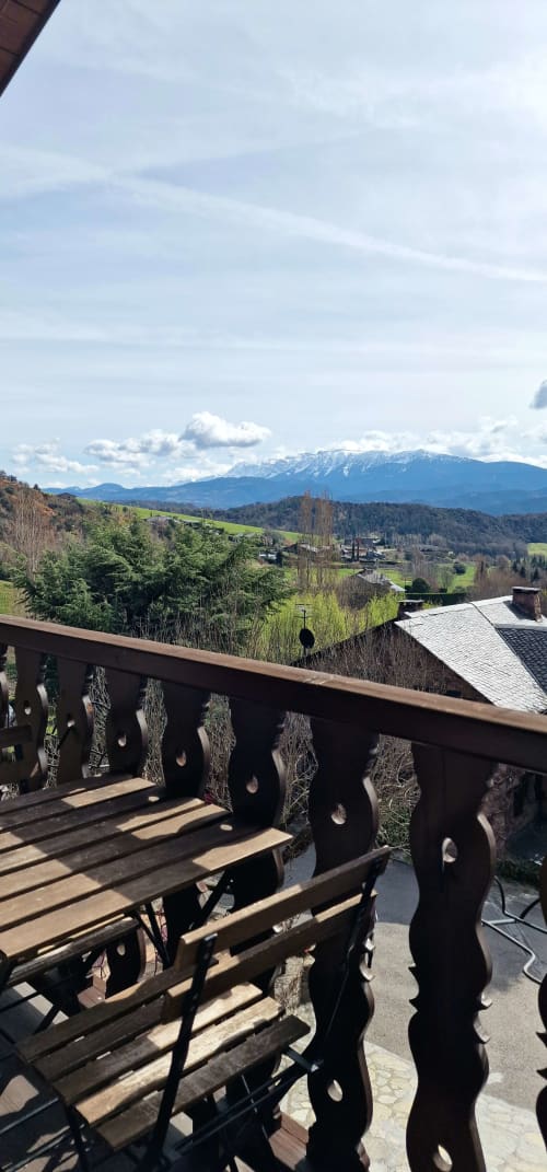 Vista desde el balcón del Hotel Mas D'En Roqueta con montañas, valles verdes y picos nevados en la campiña española