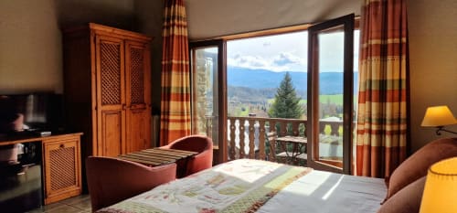 Habitación doble deluxe con balcón en Hotel Mas D'En Roqueta, España, con vistas a la montaña y muebles de madera